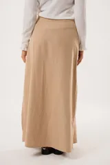 Falda larga color beige confeccionada en tela suave con acabado tipo piel de durazno y cierre invisible lateral.