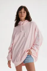 Buzo hoodie rosa con cordones blancos y bolsillo tipo canguro. Estampado frontal pequeño con el logo de Levi's en blanco y estampado grande en la manga con la frase "Endless Dreams" en letras cursivas blancas.