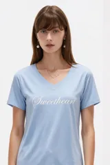 Remera negra de algodón, con cuello en V, mangas cortas, corte al cuerpo y estampa frontal con la frase "Emotionally Unavailable" en letras rosadas.