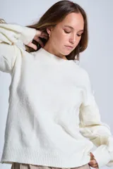 Sweater color crema de hilado frizado con cuello redondo y apliques de flores color beige en las mangas.