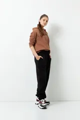 Pantalón de jogging negro de algodón con interior de felpa, bolsillos laterales, cintura elástica y puños ajustados.