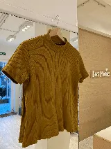 Polera blanca de morley con cuello alto y mangas cortas.