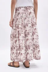 Pollera larga de mujer, con paneles y estampado abstracto en tonos marrones sobre fondo crudo.