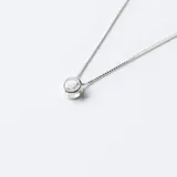 Conjunto de cadena fina de plata con dije de punto de luz circular engastado con una circonia brillante.