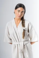 Bata kimono corta color beige, confeccionada en tela waffle de algodón. Tiene mangas al codo, lazo de ajuste en la cintura y detalle de vivo en la solapa.