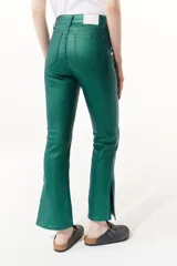 Pantalón jean plateado de tiro medio/alto con silueta levemente acampanada desde la rodilla y aberturas en los tobillos.