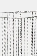 Cinturón metálico plateado con flecos de cadenas finas y brillantes. Cierre con mosquetón.