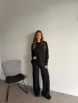 Buzo de punto color marrón chocolate, con cuello redondo y diseño holgado de manga larga con textura de trenzas verticales.