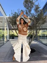 Pantalón de jean azul oscuro con diseño fluido y volados en las piernas.
