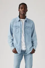 Camisa de denim celeste de calce recto, con cuello clásico, cierre con botones a presión, mangas largas con puños abotonados, dos bolsillos con solapa abotonada en el pecho y canesú en la parte delantera y trasera.