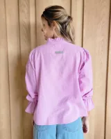 Blusa de algodón con cuello mao y volados, mangas largas con puños elásticos y corte holgado.