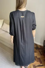 Vestido marrón de lino con escote en V, mangas cortas abullonadas, bolsillos laterales y tajos en los laterales.