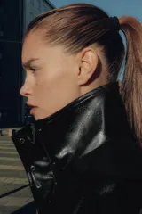 Chaqueta de efecto piel con cuello subido, manga larga con puños y bajo elástico. Presenta cierre frontal con cremallera y botones a presión ocultos, además de bolsillos laterales y forro interior.