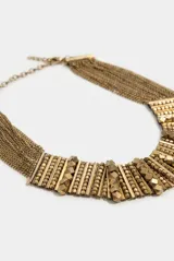 Gargantilla choker rígida de metal dorado con diseño texturizado de eslabones y cuentas en relieve.
