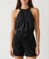 Blusa negra de lino con escote halter y fruncido en el cuello, diseño sin mangas de corte fluido y holgado.