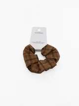 Colita de pelo tipo scrunchie con estampado de cuadros escoceses en tonos beige y negro.