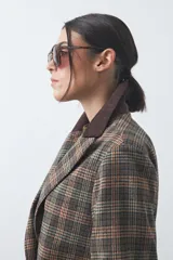 Blazer de corte relajado con estampado de cuadros tipo pied de poule en tonos rojizos y verdes. Presenta solapas clásicas en color azul oscuro y estructura definida.