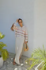 Falda larga tejida color marrón con brillo metálico, corte al cuerpo, abertura alta en la pierna y recortes laterales con cordones ajustables.