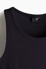 Musculosa negra de punto acanalado, corte ajustado y cuello redondo.