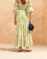 Blusa corta con estampado floral en tonos amarillo y verde, escote bardot, mangas abullonadas 3/4 con puños elásticos y espalda elastizada.