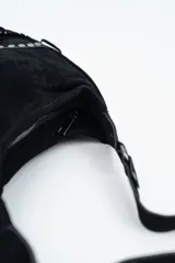 Cartera de hombro tipo hobo confeccionada en gamuza negra, con diseño de flecos largos en la parte inferior y detalles de tachas metálicas plateadas en los laterales.