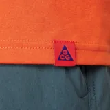 Remera Nike ACG de alta densidad en color naranja, de corte amplio y relajado, con cuello redondo de canalé y gráfico estampado en el pecho.
