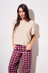 Chaleco de punto con textura acanalada y acabado brillante, de corte holgado, cuello redondo y mangas cortas estilo sisa.