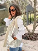 Camisa blanca de algodón con cuello clásico, cierre frontal de botones y mangas largas abullonadas con diseño de volados y puños elásticos.