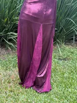 Vestido largo bordó con escote en V, cut-outs laterales bajo el busto, breteles finos cruzados en la espalda y falda larga combinada con paneles godet en el ruedo.