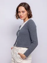 Top marrón de punto, manga larga y escote en V con cierre de dos botones. Incluye una remera blanca de cuello alto debajo.