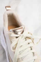 Zapatillas urbanas de cuero color blanco y beige, con suela chunky blanca.