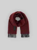 Bufanda rectangular color rojo oscuro con textura y flecos en los extremos.