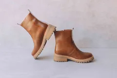 Botas de cuero color crema con cierre lateral y elástico en los laterales. Suela track color caramelo.