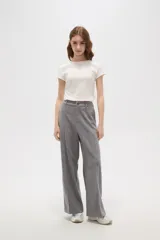 Pantalon de corte holgado y tiro alto, confeccionado en tejido de punto gris con costuras frontales verticales que simulan una tabla.