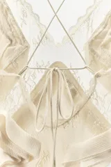Vestido largo de georgette con escote en pico, tirantes finos cruzados en la espalda y detalle de volantes aplicados en el pecho.