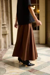 Falda larga de algodón en color negro, con diseño de tablas anchas y corte evasé.