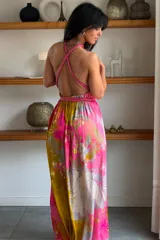 Vestido largo de seda con estampado abstracto en tonos marrones, beige y destellos dorados, con escote en V profundo, tirantes de cuerda anudados al cuello y la cintura, y tajo lateral en la falda.