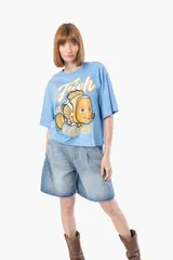 Remera celeste con estampado de Nemo y texto en color naranja.