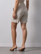 Short azul de lino con pretina elastizada, lazo de ajuste y bolsillos delanteros.