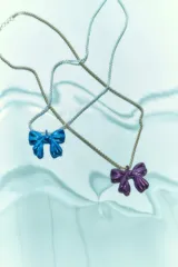 Collar con dije de moño metálico y cadena de eslabones.