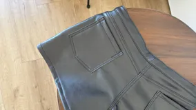 Short negro de ecocuero con cierre y botón a presión.