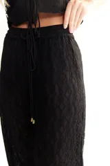 Pantalón negro de encaje con cintura elástica, corte recto y calce suelto.