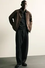 Pantalón de corte balloon fit confeccionado en tejido con viscosa. Presenta cintura ajustable con cinturón integrado, pliegues frontales, bolsillos laterales y bolsillos traseros de doble vivo. Cierre frontal con cremallera y botón.