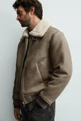 Cazadora de corte regular fit confeccionada en tejido efecto piel color marrón, con interior de borreguillo a contraste. Presenta cuello solapa con trabilla, cierre frontal de cremallera, bolsillos de vivo en la cadera y puños y bajo acabados en rib.
