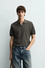 Polo de punto tejido en hilatura de algodón color azul marino, de corte regular fit, con cuello solapa y abertura frontal sin botones, manga corta y terminaciones en rib.