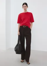Chaleco rojo de punto fino, de diseño recto, cuello redondo y manga corta.