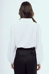 Camisa bordó de manga larga abullonada, con costuras en contraste color blanco, cuello camisero y cierre frontal de botones.