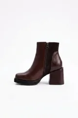 Botin de cuero vacuno color marrón, con taco cuadrado de 6 cm y diseño combinado que incluye texturas lisas y efecto reptil en el talón y el taco.
