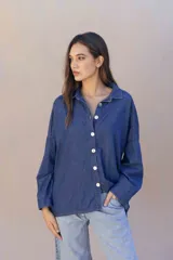 Camisa de denim suave con lavado clásico, corte oversize, cuello camisero y cierre frontal con botones a contraste.