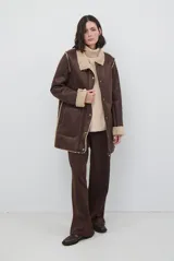 Chaquetón de efecto cuero color marrón con interior y detalles en corderito beige. Posee cierre frontal con botones a presión, bolsillos laterales y cuello solapa.